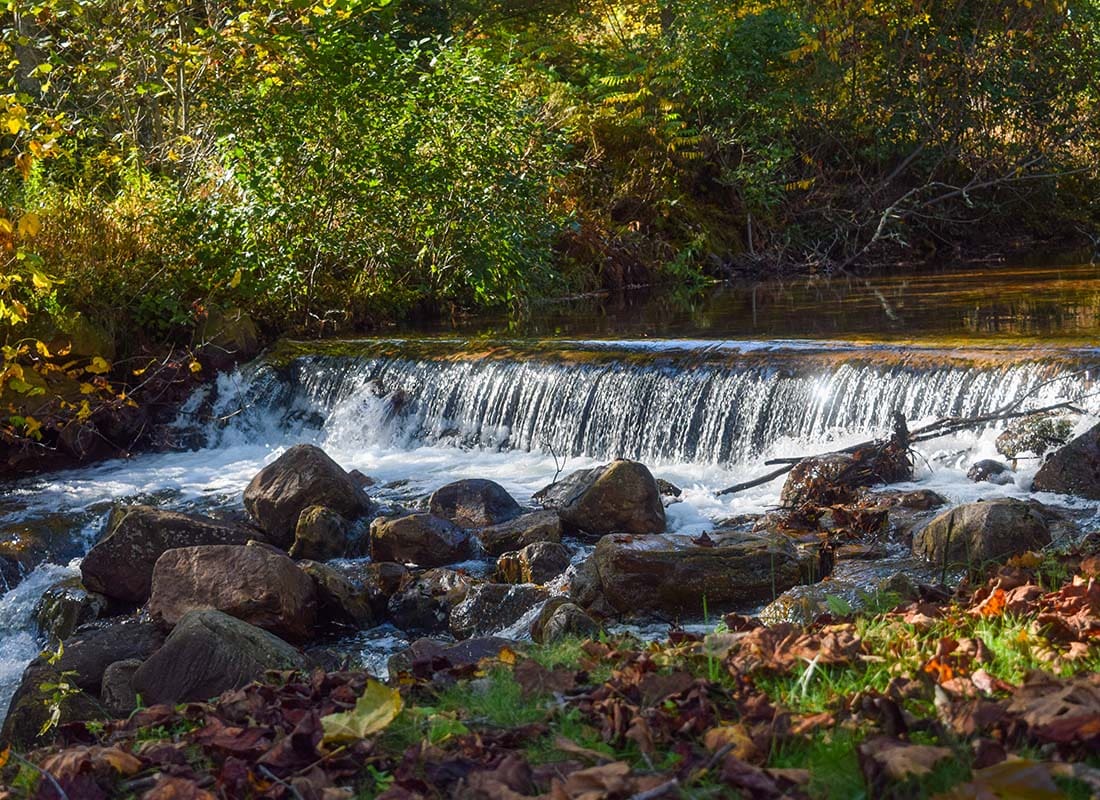 Blacksburg, VA - Scenic View of a Waterfall in a River with Rocks in Blacksburg Virginia on a Sunny Afternoon
